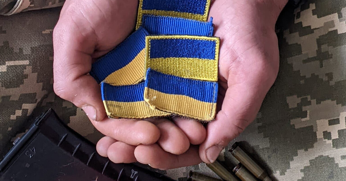 Шеврон з українським прапором в руках чоловіка