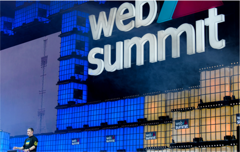 Превʼю до наступного матеріалу. На ньому зображена велика сцена на заоді WebSummit, на якій спікер проводить лекцію 