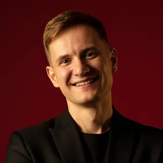 Портрет Андрія Самбора на бордовому фоні.